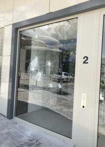 Photo des fissures d'une vitre d'immeuble suite à des impacts